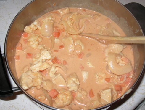 Add browned chicken cubes and simmer 5 minutes more before adding diced red pepper and frozen peas.